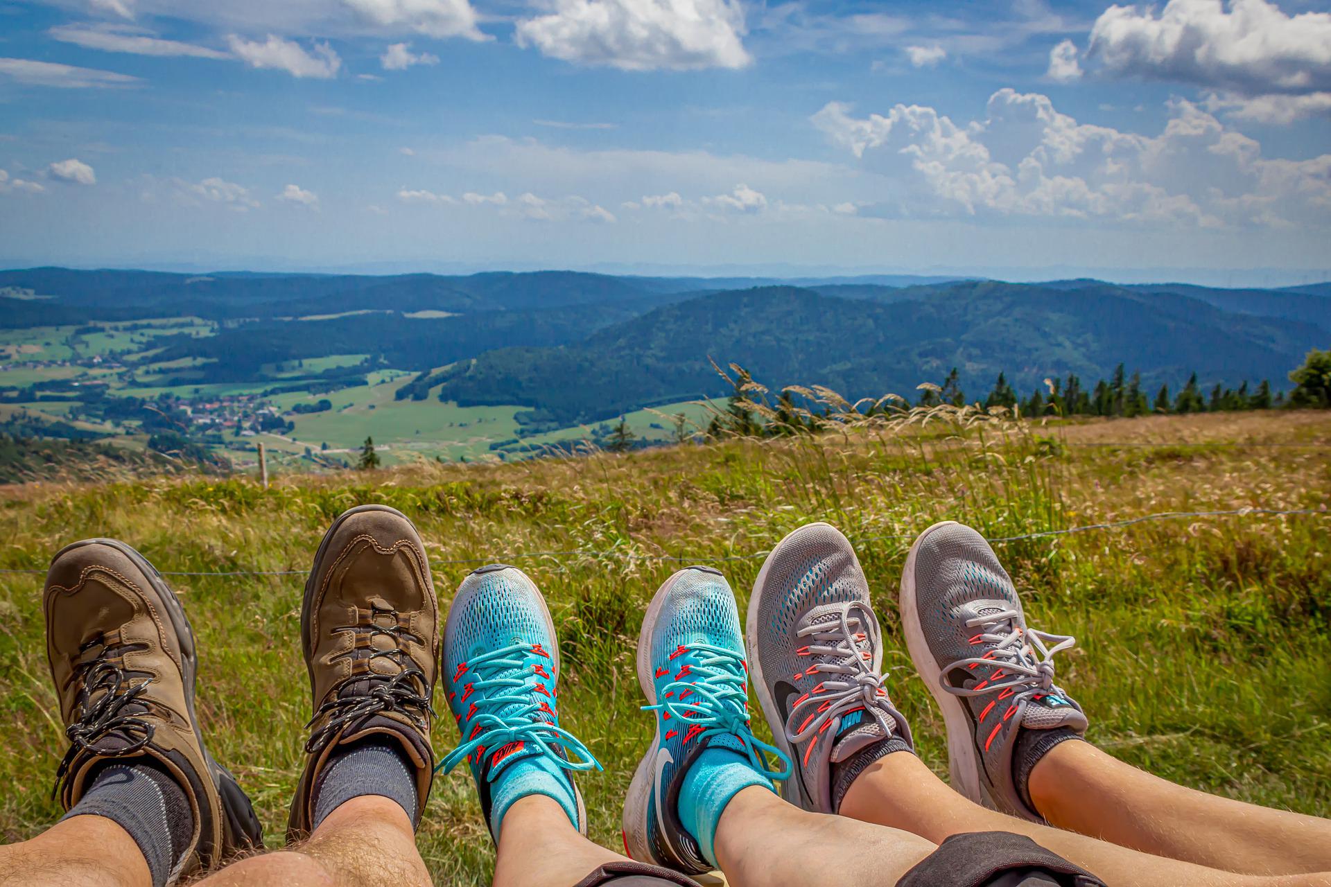 Feet stretched out in the grass after a hike, hills beyond