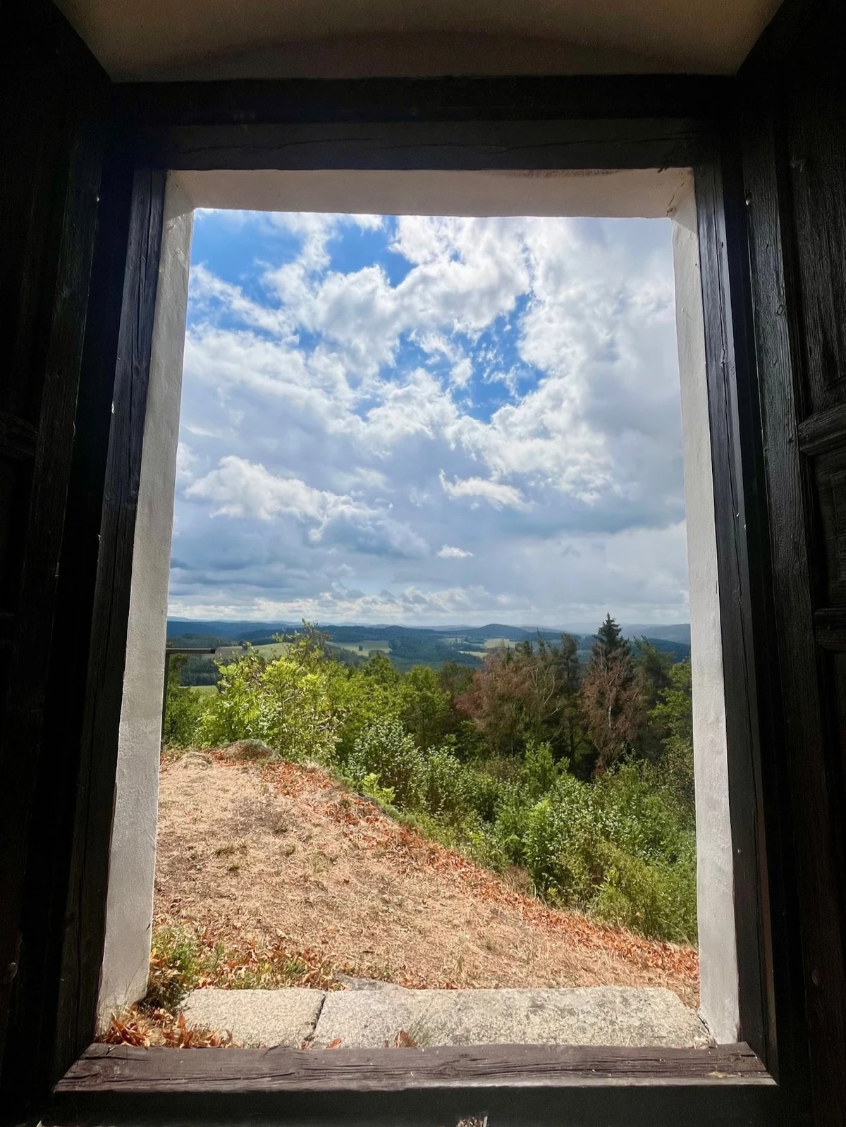 A view through the window of the Thurmberg tower over forested hills