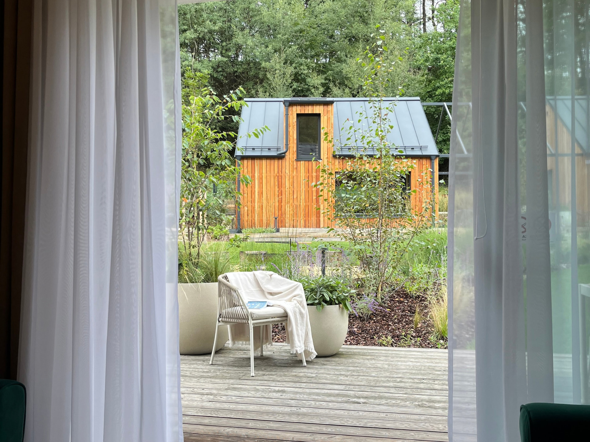 Looking out from the terrace to the wooden cabin in the garden