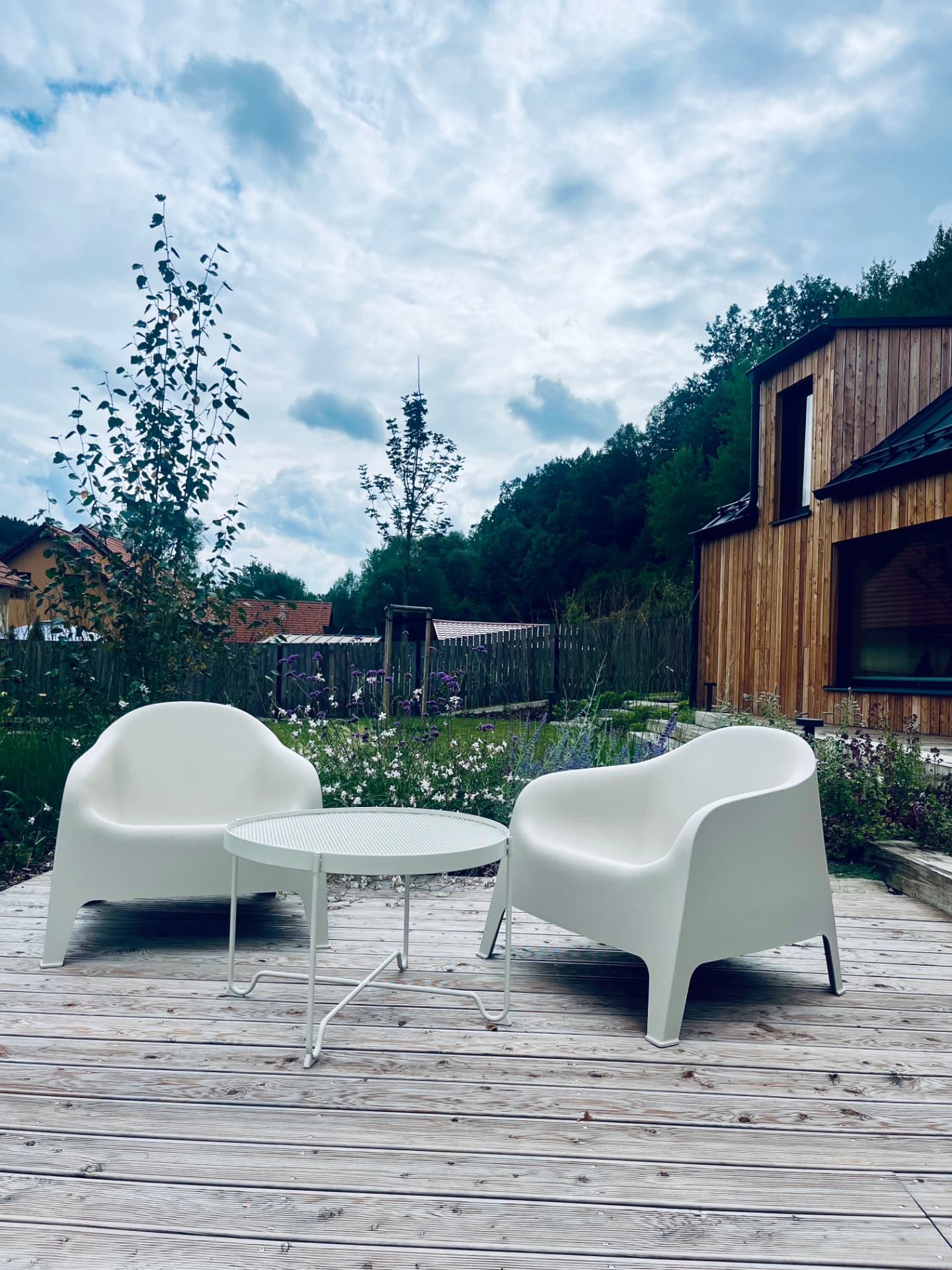Two armchairs and a table on the wooden deck