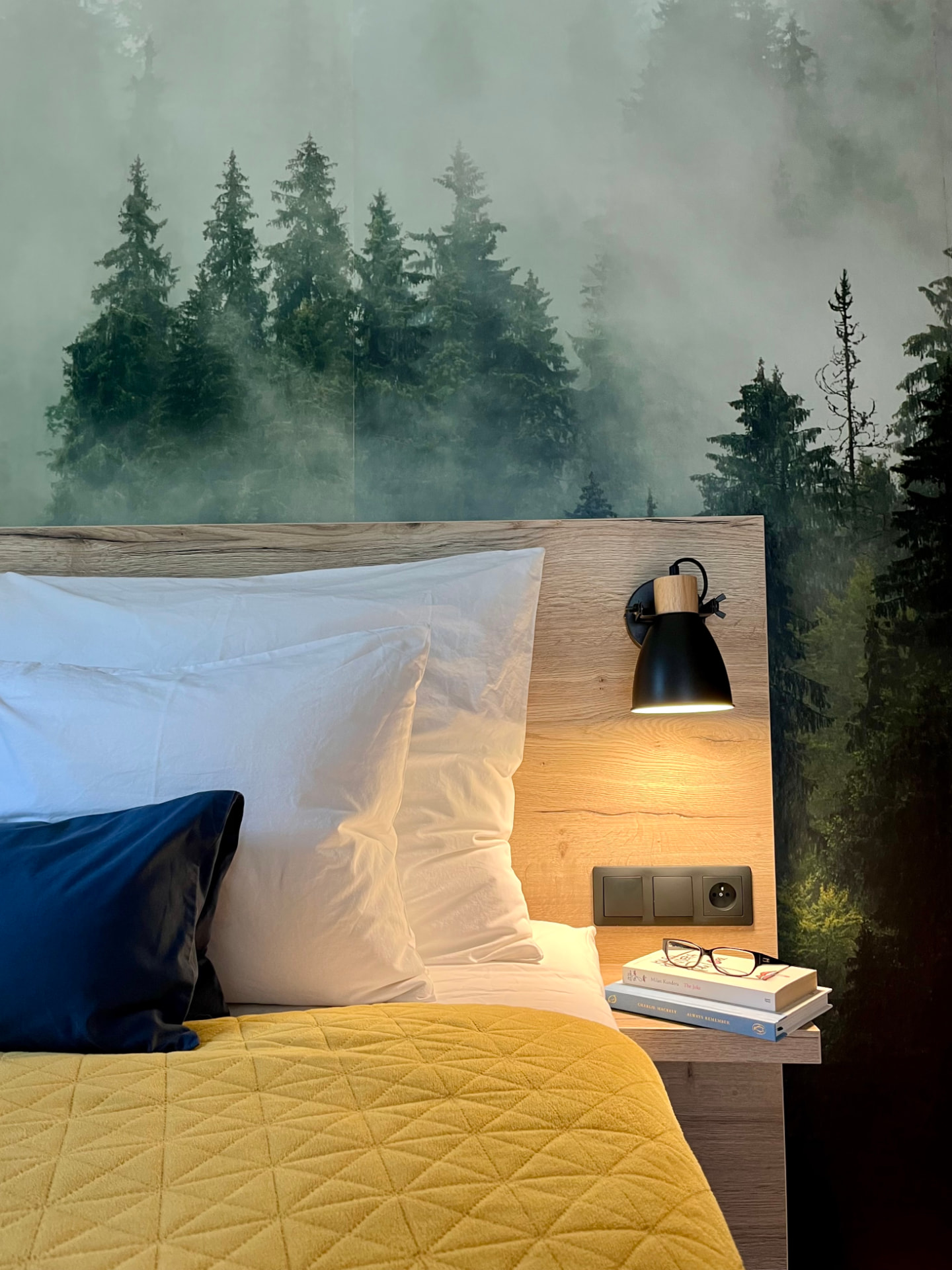 Bedroom with a forest mural behind the bed