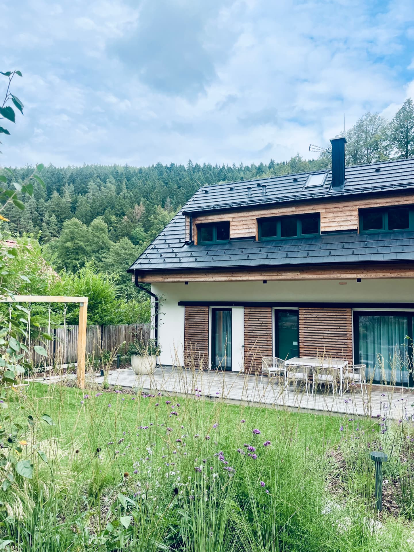 The house with its terrace and flowering garden