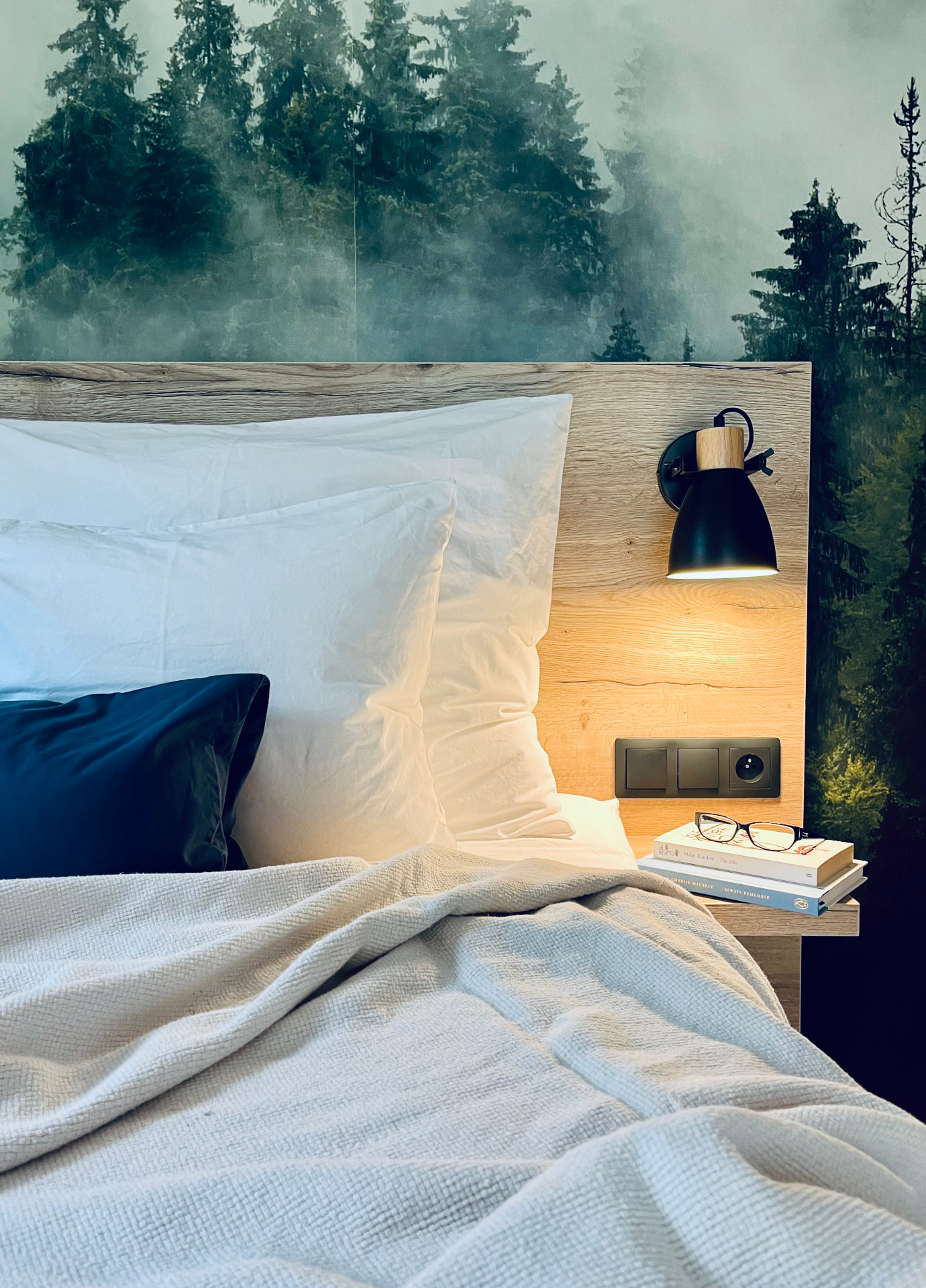 Bed with a forest mural in a HYGGE apartment